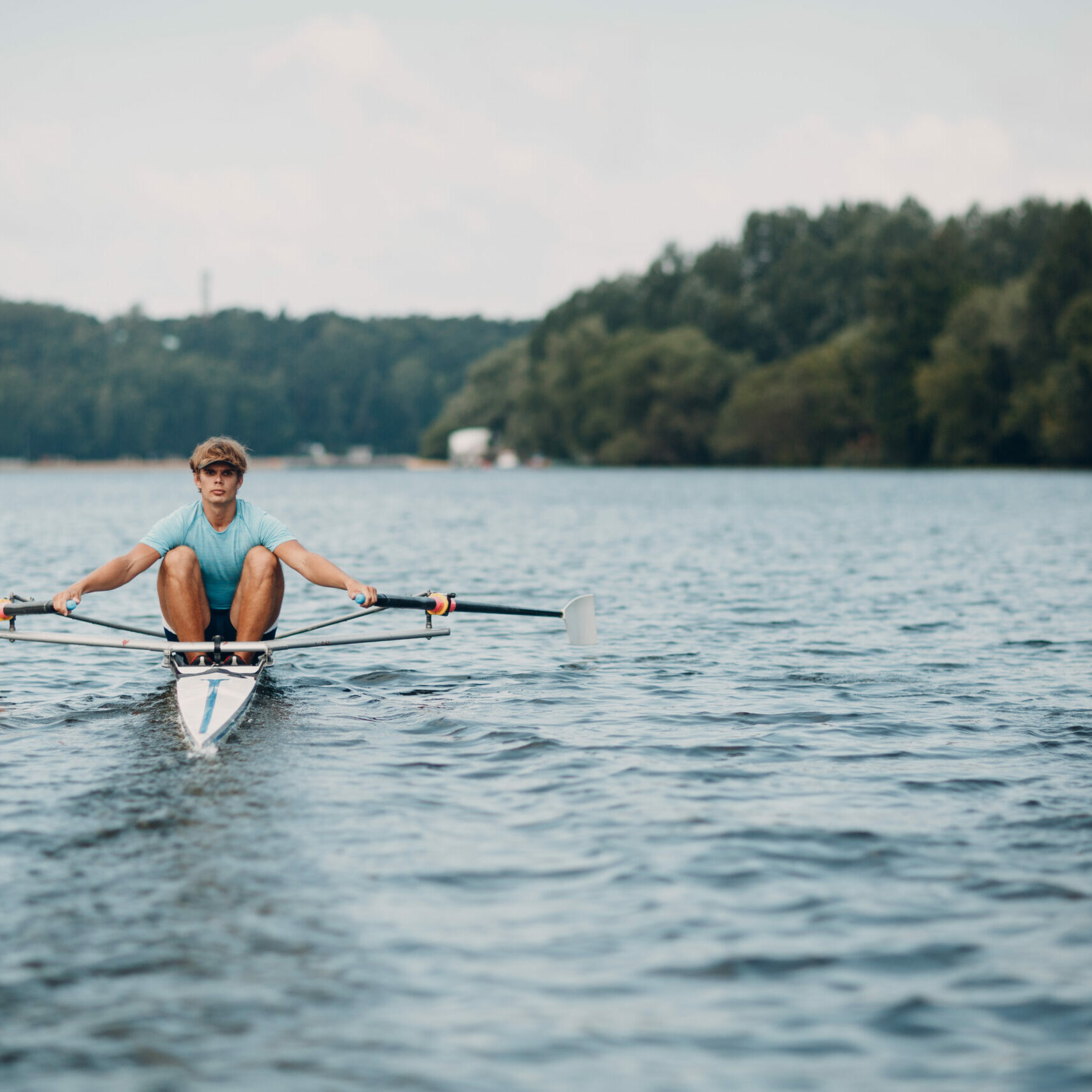 Sportsman single scull man rower rowing on boat Sportsman single scull man rower rowing technique on boat. Paddle oar splash movement